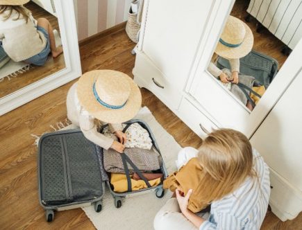 A woman and a child packing a suitcase