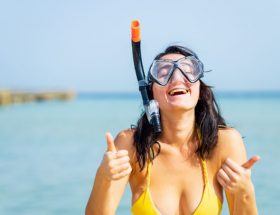 A beautiful woman with a snorkel scuba mask in a beach